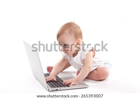 Foto d'archivio: Curious Smiling Child Sitting Near The Laptop On A White Backgro