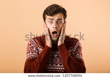 [[stock_photo]]: Image Of Intimidated Man 20s With Stubble Wearing Knitted Sweate