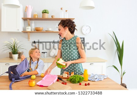 Stok fotoğraf: Beautiful Brunette Mother And Her Daughter Packing Healthy Lunch