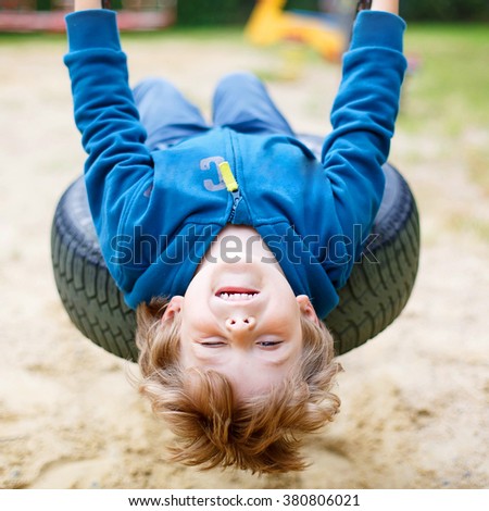 ストックフォト: Funny Kid Boy Having Fun With Chain Swing On Outdoor Playground Child Swinging On Warm Day Active