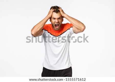 Foto stock: Angry Aggressive Mascular Sportsman Looking Furious Grab Head In Rage And Fury Shouting And Grima