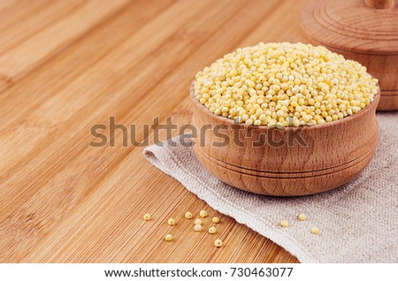 ストックフォト: Millet In Wooden Bowl On Brown Bamboo Board Closeup Rustic Style Healthy Dietary Groats Backgrou