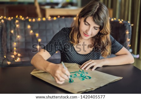 Foto d'archivio: Go Green Calligrapher Young Woman Writes Phrase On White Paper Inscribing Ornamental Decorated Let