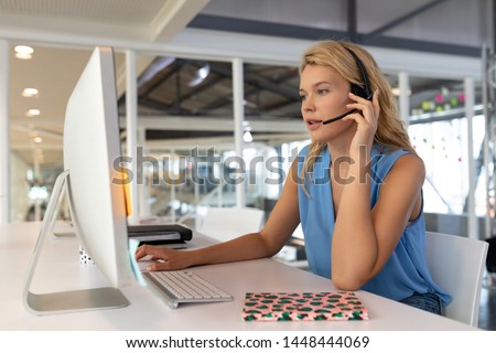 Stock photo: Side View Of Young Diverse Executives Working On Personal Computer While Talking On Headset In Moder