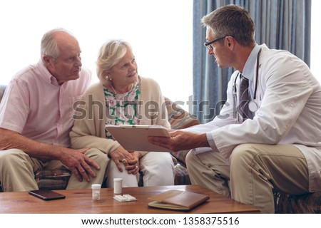 [[stock_photo]]: Front View Of A Caucasian Male Doctor Showing Prescription To Senior Woman In Clinic Room