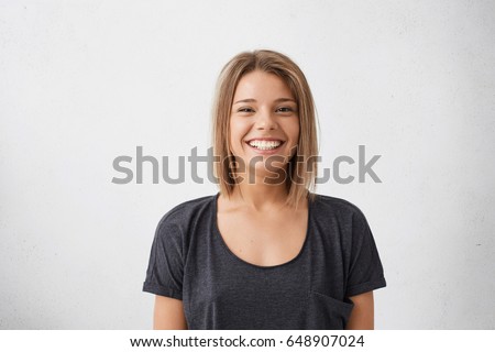 Foto stock: Photo Of Pleased Young Woman Smiling And Looking At Camera