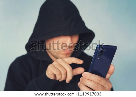 Stock fotó: Faceless Hooded Person Using Mobile Phone Identity Theft Concep