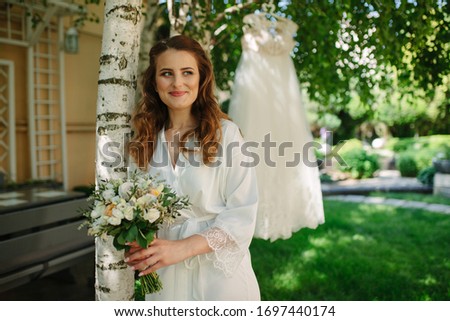 Foto d'archivio: Beautiful Brunette Woman With Bouquet Posing In A Wedding Dress