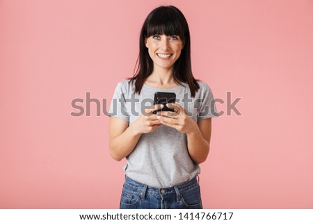Stock photo: Happy Cheerful Young Woman Posing Isolated Over Pink Wall Background Holding Feather Leaf