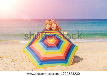 Foto stock: Mother And Son On The Beach In A Hat And Beach Umbrella Vertical Format For Instagram Mobile Story O