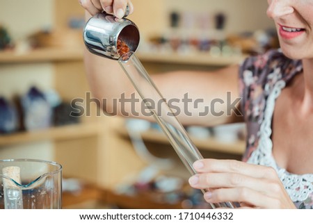 Foto d'archivio: Woman Putting Red Gemstones In A Tube