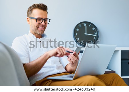 Stock fotó: Cheerful Young Bearded Man In Glasses Talking On Mobile Phone