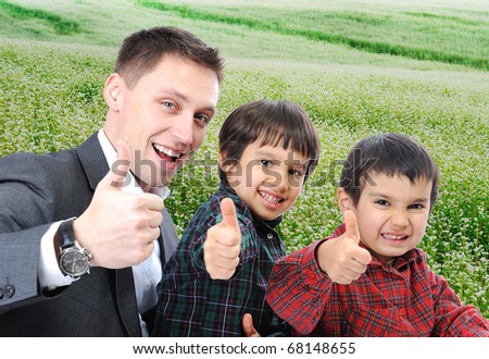Fiatal apa és két fia szabadtéri ül, és növekszik a hüvelykujját Stock fotó © Zurijeta