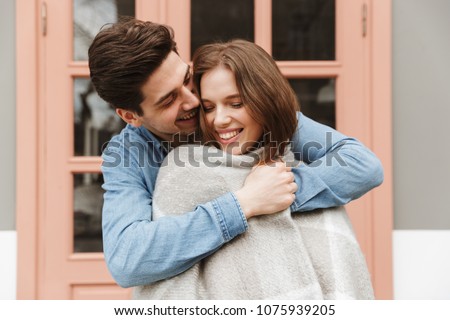 ストックフォト: Photo Of Smiling Couple Standing Outside And Man Wrapping His W