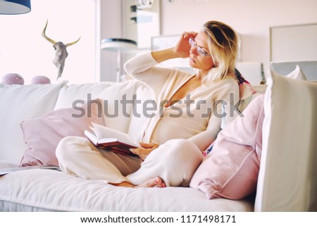 Stok fotoğraf: Pregnant Woman Sitting In Couch At Lounge Room Young Blond Pensive Serious Bored Female In Morning