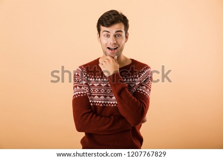 Foto stock: Image Of Excited Man 20s With Bristle Wearing Knitted Sweater Po