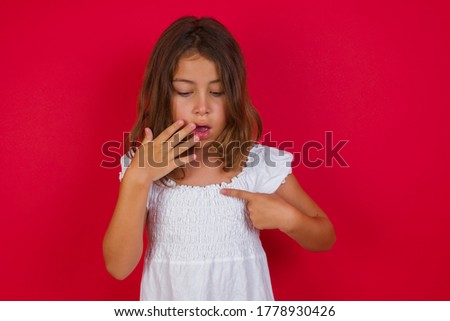 Stock fotó: Brunette Girl Surprised Looking At Price Of Red Dress With Opened Mouth