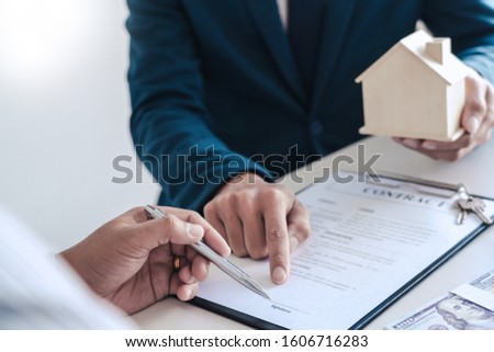 Stok fotoğraf: Real Estate Agents Explain The Document For Customers Who Come T