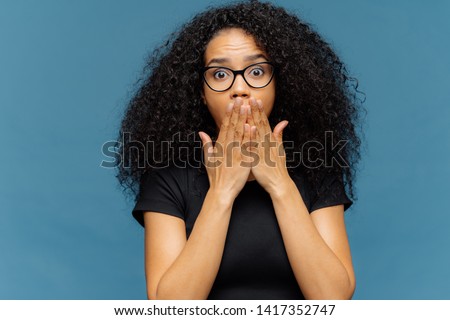 ストックフォト: Photo Of Stupefied Young Female Covers Mouth Has Bated Breath Bugged Eyes Afro Hair Cannot Belie