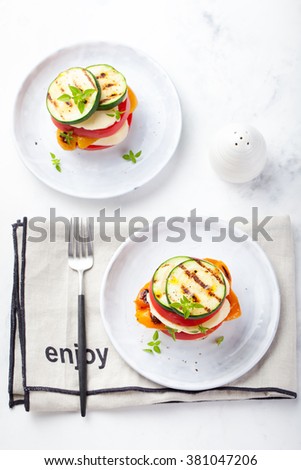 Foto d'archivio: Grilled Vegetables Cheese Gratin Stacked On A Plate Fresh Basil