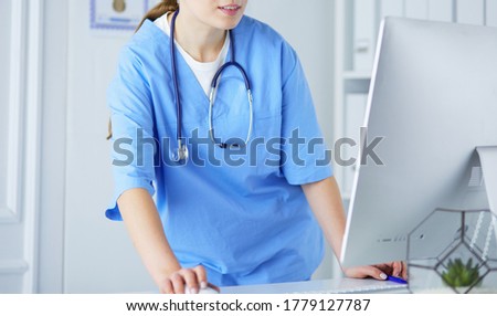 Foto stock: M · médico · escrevendo · em · uma · prancheta · na · área · de · recepção · de · um · hospi