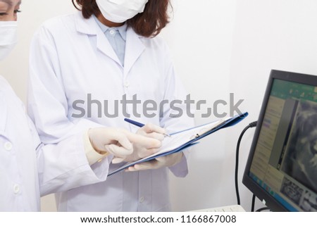 Zdjęcia stock: Crop Assistant Taking Notes Of Dental X Ray