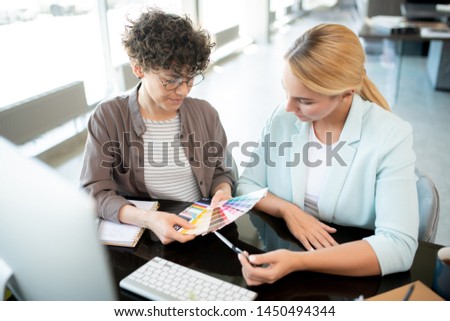 Foto d'archivio: Young Female Designers Consulting While Working Over New Interior Collection