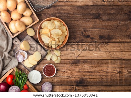 [[stock_photo]]: Fresh Organic Homemade Potato Crisps Chips With Raw Yellow Potatoes In White Wooden Box On Light Kit