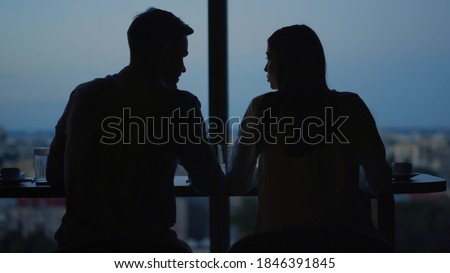 Stockfoto: Silhouette Of A Loving Couple Against A Window With A View Of The Night City Its Raining Outside