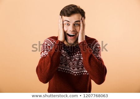 Foto d'archivio: Image Of Surprised Man 20s With Stubble Wearing Knitted Sweater