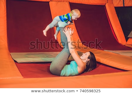 Stock photo: Mother And Her Son Jumping On A Trampoline In Fitness Park And Doing Exersice Indoors