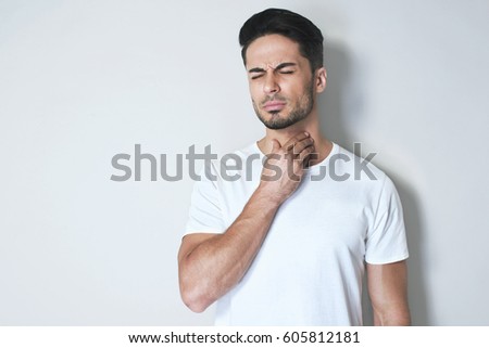 Foto stock: Young Asian Man Having Sore Throat And Touching His Neck With Wearing Medical Mask