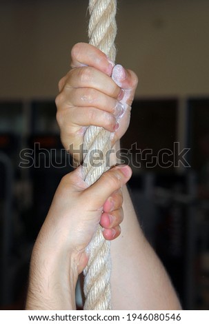Stockfoto: Crossfit Gym Man Holding Hand A Climbing Rope