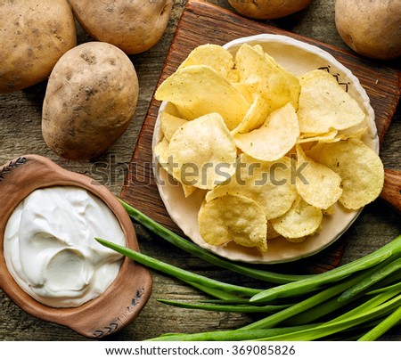 Foto stock: Fresh Organic Homemade Potato Crisps Chips In Wooden Bowl With Sour Cream And Red Onions And Spices