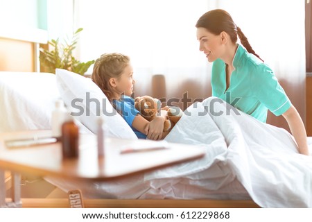 Stockfoto: Little Girl In Hospital Bed With The Nurse