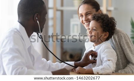 Foto stock: Family General Practitioner Examines Child Listens Lungs With Stethoscope Makes Prescription Pose