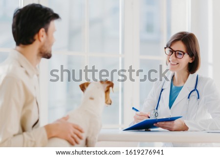 Zdjęcia stock: Man Brings His Pet Fot Vet Examination In Clinic Tells Symptoms Of Ill Dog Happy Woman Veteranian