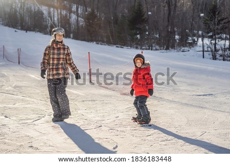 Foto stock: Mother Teaches Son Snowboarding Activities For Children In Winter Childrens Winter Sport Lifesty