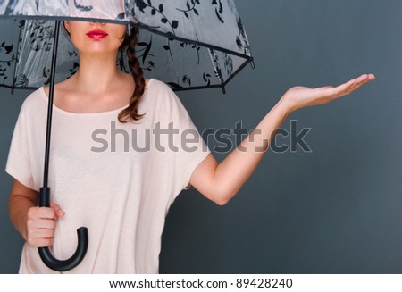 Сток-фото: Young Fashionable Woman Holding Umbrella Standing Against Grey B