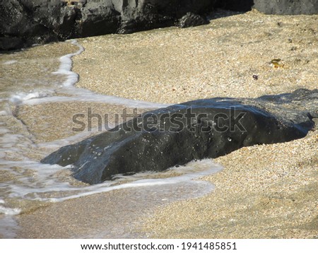 Foto d'archivio: Ocean Waves Washing Over Smooth Volcanic Rocks