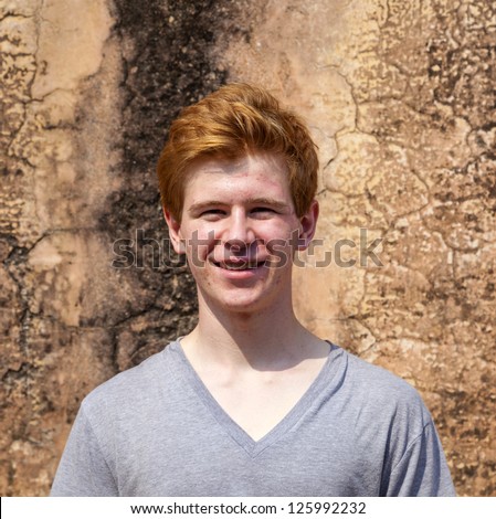 Foto stock: Portrait Of 16 Years Old Boy With Red Hair With Grunge Backgroun