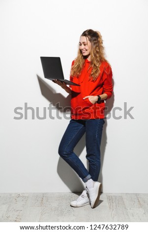 Stockfoto: Full Length Photo Of Cute Woman 20s Wearing Red Sweatshirt Holdi