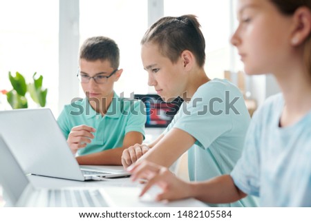 Group Of Contemporary Learners Of Middle School Looking At Laptop Display Foto stock © Pressmaster