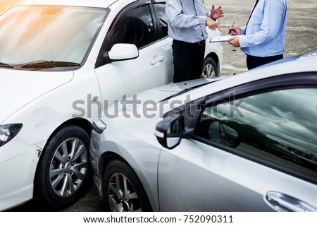 Foto stock: Insurance Agent Writing On Clipboard While Examining Car After A