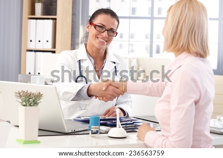 Stock fotó: Doctor Shakes Hands At Medical Office With Patient Wearing Glas