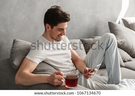 Stock photo: Handsome Man In Basic T Shirt Smiling And Holding Mobile Phone I