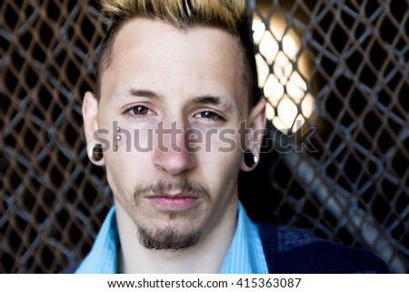 Foto stock: Young Man Revealing His Sadness And Depression Against A Chain Link Fence