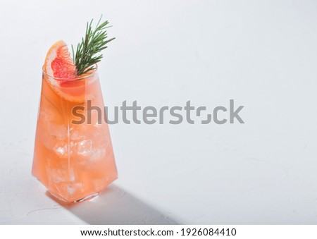 Сток-фото: Red Grapefruit Summer Juice Cocktail In Modern Luxury Martini Glass With Rosemary And Fruit Slice On
