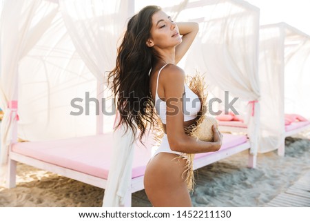 [[stock_photo]]: Alluring Woman In Swimsuit Standing Outdoors And Holding Old Boombox