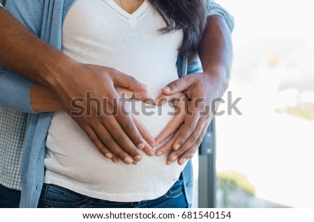 Foto stock: Close Up Parents Hands Making A Heart On The Belly Of The Pregn